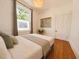 First bedroom viewed from the hallway — Cozy Heritage 2BR with Lush Private Garden Patio