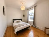 First bedroom with a queen bed — Cozy Heritage 2BR with Lush Private Garden Patio