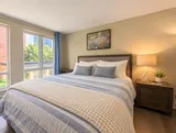 First queen bedroom with natural light — Bright 2BR Retreat