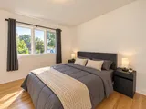 First queen bedroom with window and bedside lamps — Modern 3BR Spacious Home