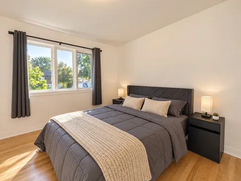 First queen bedroom with window and bedside lamps — Modern 3BR Spacious Home
