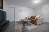 Living room with sofa and television — Rehoboth 1BR in Laval