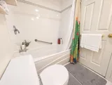 Bathtub and shower in the first bathroom — Bright 2BR Retreat