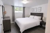 Bedroom with window and bedside tables — Rehoboth 1BR in Laval