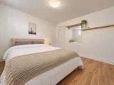 First queen bedroom with mirror and wood shelves — Cozy 2-Bedroom Retreat