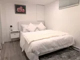 Bedroom with bed and bedside lighting — Stylish Modern 1BR with EV Charger