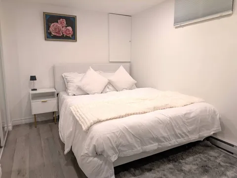 Bedroom with bed and bedside lighting — Stylish Modern 1BR with EV Charger