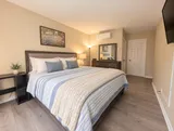 First queen bedroom with dresser, TV and air conditioning — Bright 2BR Retreat