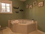 Bathroom with corner bathtub — Modern 1BR with Desk Near YUL