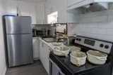 Kitchen with stove and refrigerator — Rehoboth 1BR in Laval
