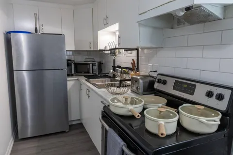 Kitchen with stove and refrigerator — Rehoboth 1BR in Laval