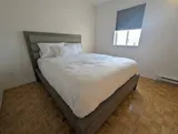 Bedroom with bed and bedside lighting — Spacious 2BR Holiday Home Near YUL