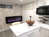 Kitchen island beside the fireplace feature — Stylish Modern 1BR with EV Charger