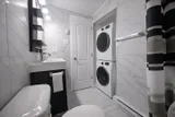 Bathroom with sink and stacked laundry appliances — Rehoboth 1BR in Laval