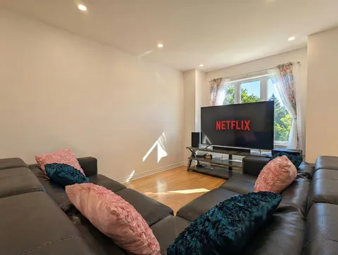 Living room with sofa and television — Spacious 2BR Holiday Home Near YUL