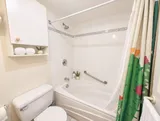 First bathroom with bathtub and grab bar — Bright 2BR Retreat