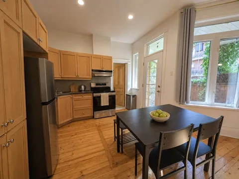 Dining area with table and heritage woodwork — Cozy Heritage 2BR with Lush Private Garden Patio