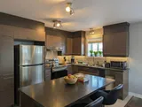 Kitchen island and counter seating — Modern 1BR with Desk Near YUL
