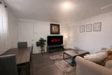 Living room with sofa and television — Rehoboth 1BR in Laval