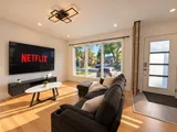 Living room with sectional sofa, television and large windows — Modern 3BR Spacious Home