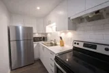 Kitchen with stove and refrigerator — Rehoboth 1BR in Laval