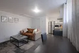 Living area opening onto the kitchen — Rehoboth 1BR in Laval