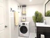 Bathroom with sink and stacked laundry appliances — Stylish Modern 1BR with EV Charger
