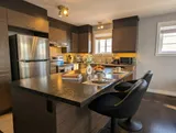 Kitchen island and counter seating — Modern 1BR with Desk Near YUL