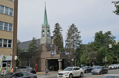 Montreal metro entrance beside Notre-Dame-des-Neiges church on a summer day
