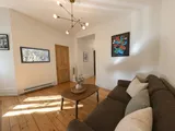 Bright living room seating area in the heritage apartment — Cozy Heritage 2BR with Lush Private Garden Patio