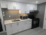Kitchenette with stove, sink and microwave — Cozy Studio Near YUL