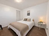 Second queen bedroom with bedside lamp and plant — Cozy 2-Bedroom Retreat