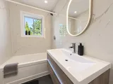 Bathtub and shower beside the bathroom window — Modern 3BR Spacious Home