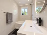 Bathroom bathtub and vanity viewed from the doorway — Modern 3BR Spacious Home