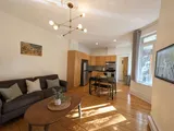 Heritage living room with warm wood floors and natural light — Cozy Heritage 2BR with Lush Private Garden Patio