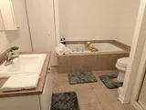 Bathroom with bathtub and vanity — Spacious 2BR Holiday Home Near YUL
