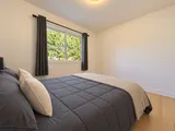 Third queen bedroom beside the window and curtains — Modern 3BR Spacious Home