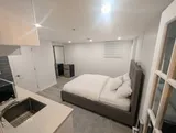 Open studio sleeping area beside the kitchenette — Cozy Studio Near YUL