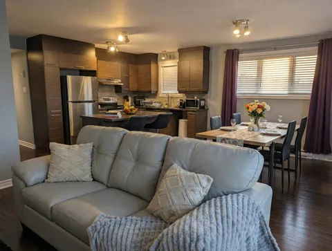 Living area opening onto the kitchen — Modern 1BR with Desk Near YUL