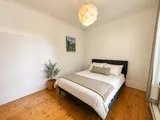 First bedroom with calm decor and natural light — Cozy Heritage 2BR with Lush Private Garden Patio