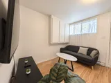 Living room with sofa, coffee table and plants — Cozy 2-Bedroom Retreat