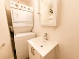 Bathroom with sink and stacked laundry appliances — Cozy Luxury in the Plateau