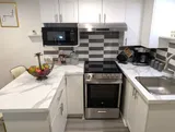 Kitchen with stove and refrigerator — Stylish Modern 1BR with EV Charger