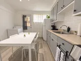 Kitchen counter with pod coffee maker and dining table — Cozy 2-Bedroom Retreat