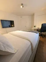 Bedroom with bed and bedside lighting — Modern 1BR with Private Bath