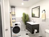 Bathroom with sink and stacked laundry appliances — Stylish Modern 1BR with EV Charger