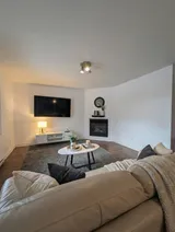 Living room with sofa and television — Modern 1BR with Private Bath