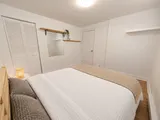 First queen bedroom with closet and textured bedding — Cozy 2-Bedroom Retreat