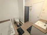 Bathtub with shower — Spacious 2BR Holiday Home Near YUL