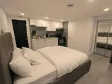 Open studio sleeping area beside the kitchenette — Cozy Studio Near YUL